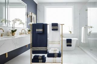 a bathroom with white, navy blue and light gold interior focus in towels